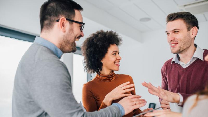 4 people standing drinking coffee chatting